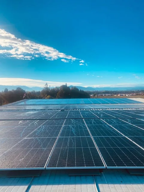 Instalación fotovoltaica industrial sobre cubierta con cielo azul y cordillera al fondo