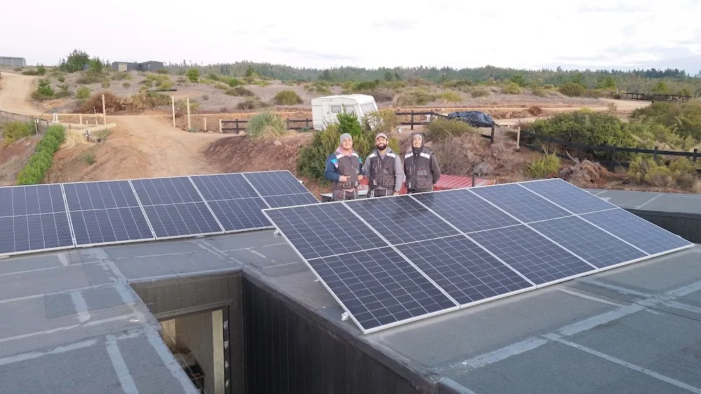 Equipo de trabajo junto a una instalación fotovoltaica residencial